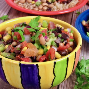 Bowl of cowboy caviar, featuring a mix of black beans, corn, tomatoes, and peppers, ready to serve with chips.