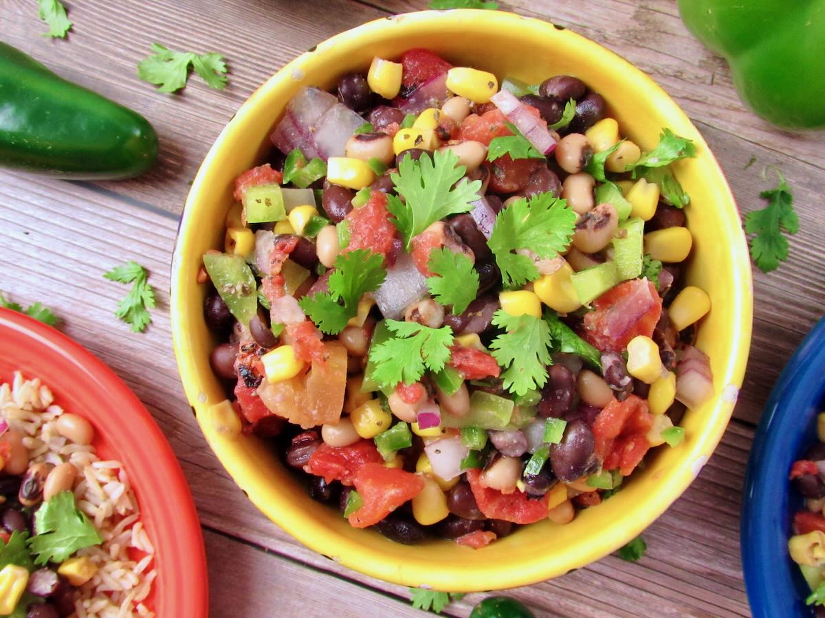 Colorful bowl of Cowboy Caviar with black beans, corn, diced tomatoes, bell peppers, and cilantro.