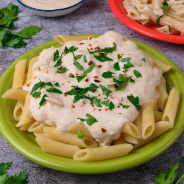 Vegan Alfredo Pasta Sauce, served on penne pasta with fresh herbs.