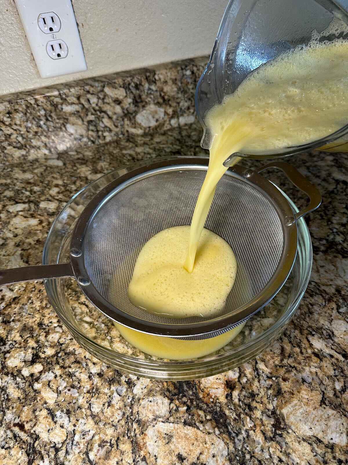 Straining the peaches from Peach Lemonade.