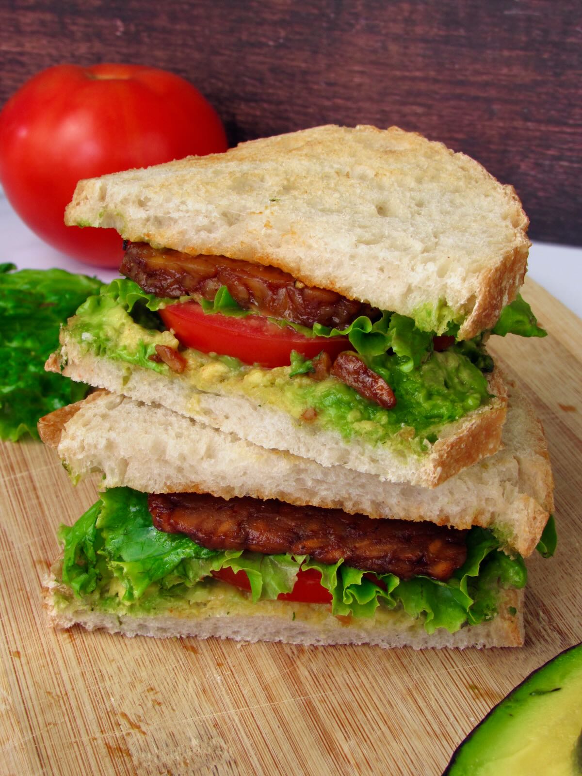 Vegan BLT sandwich on sourdough bread with smoky tempeh bacon.