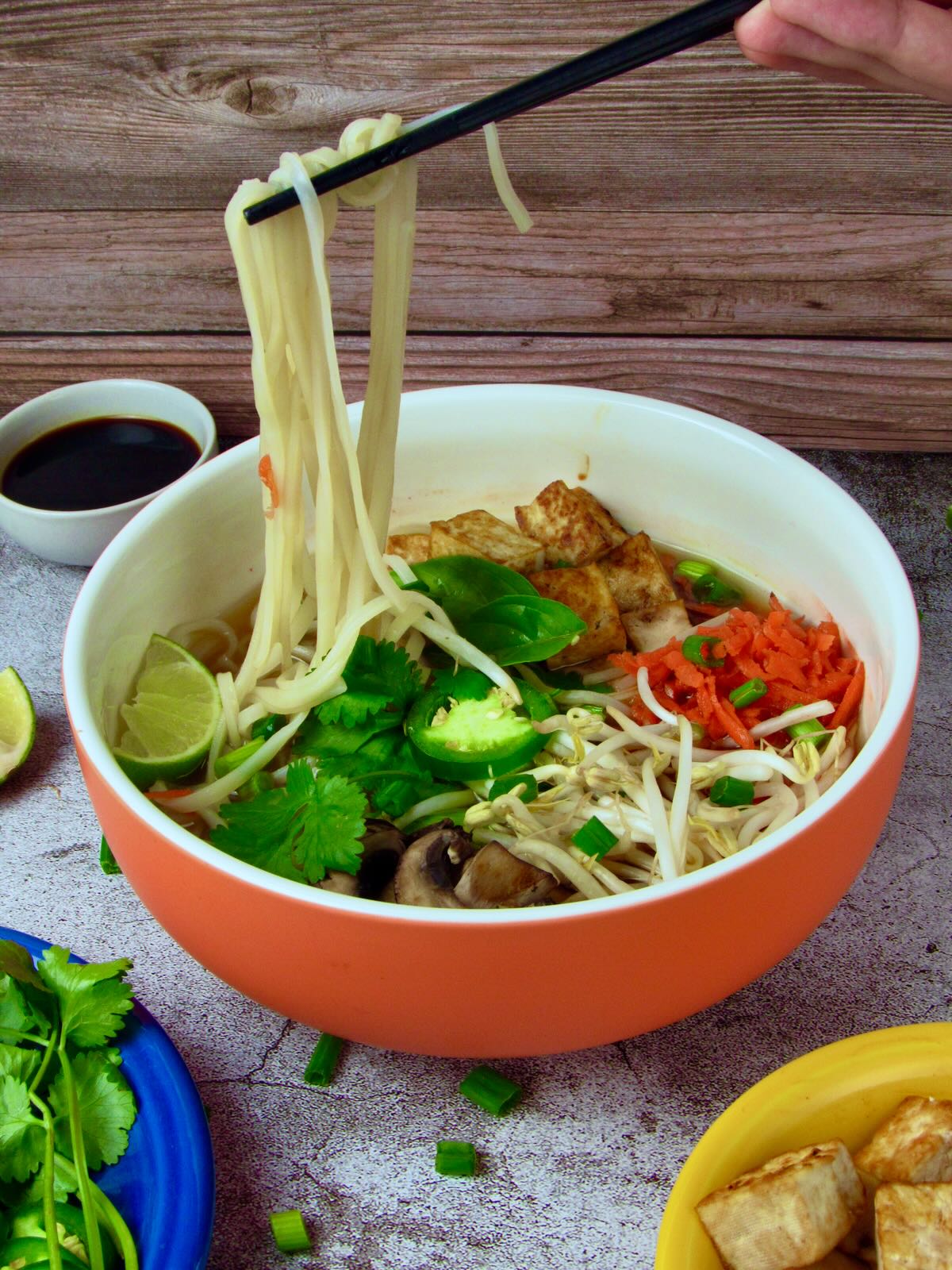 Vegan Pho noodles being eaten with chopsticks.