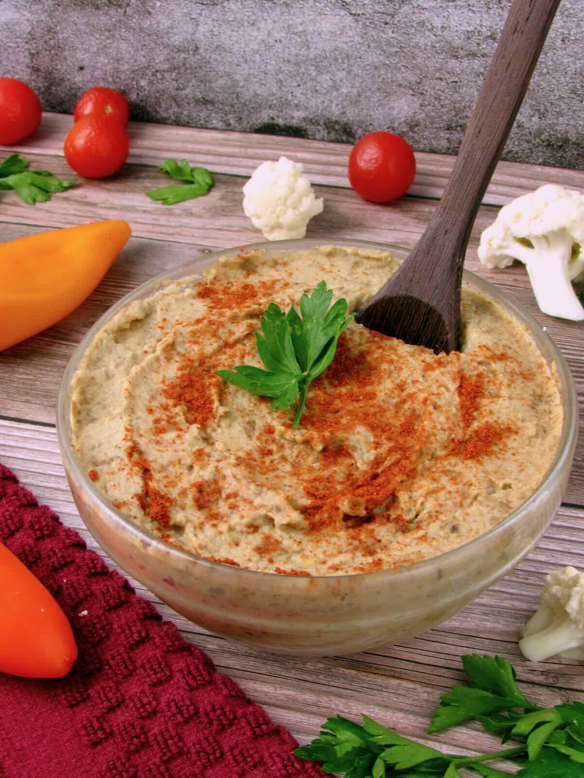 Vegan dip made with roasted eggplant, topped with paprika and parsley, and served with fresh veggies.