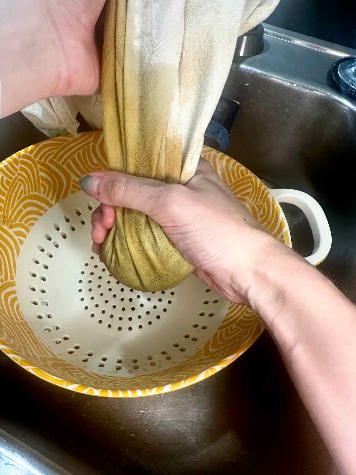 Squeezing out the excess liquid in thawed frozen spinach for a Vegan Mushroom Spinach Pasta Bake.