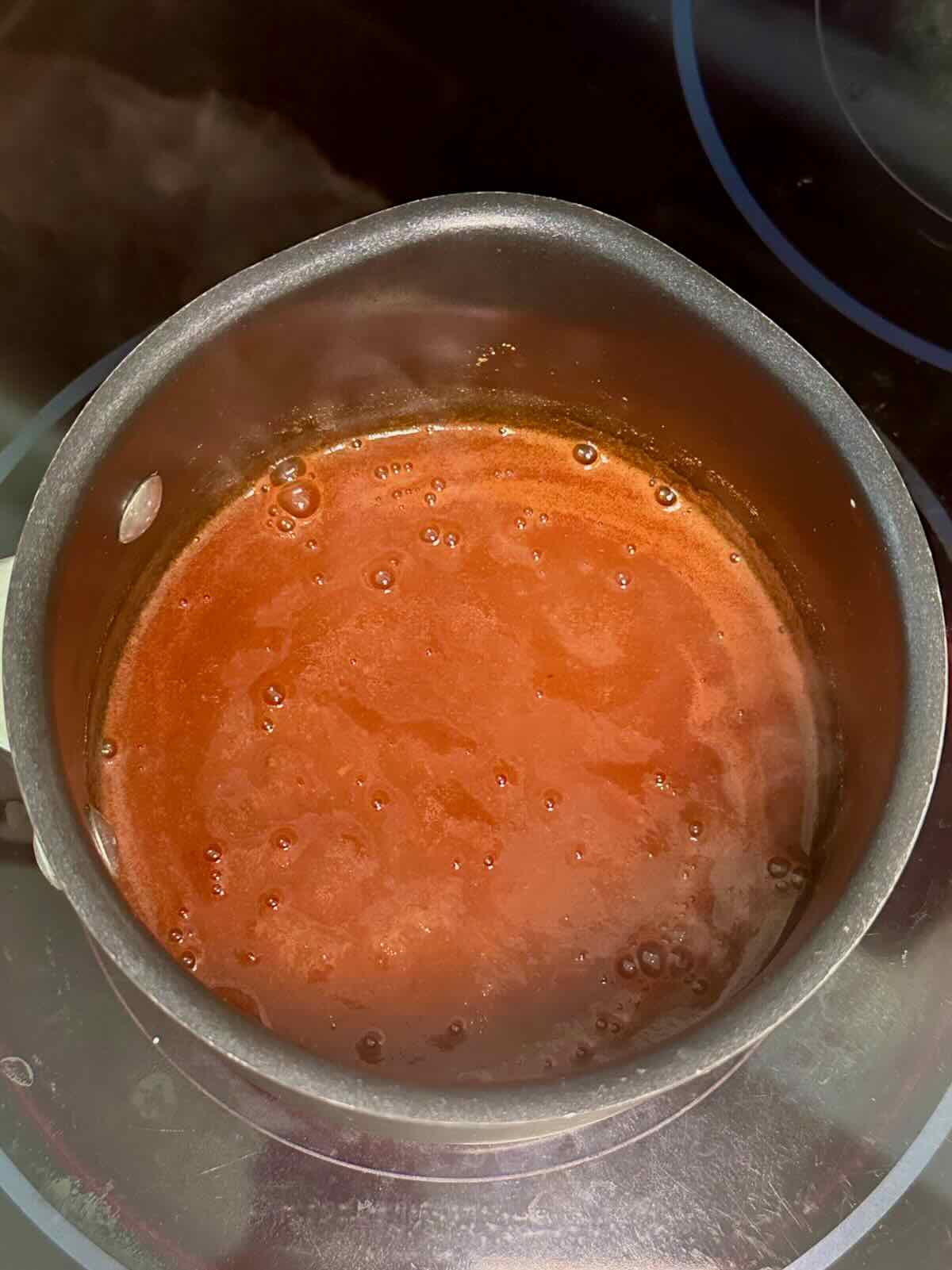 Simmering buffalo sauce for buffalo cauliflower on the stovetop.