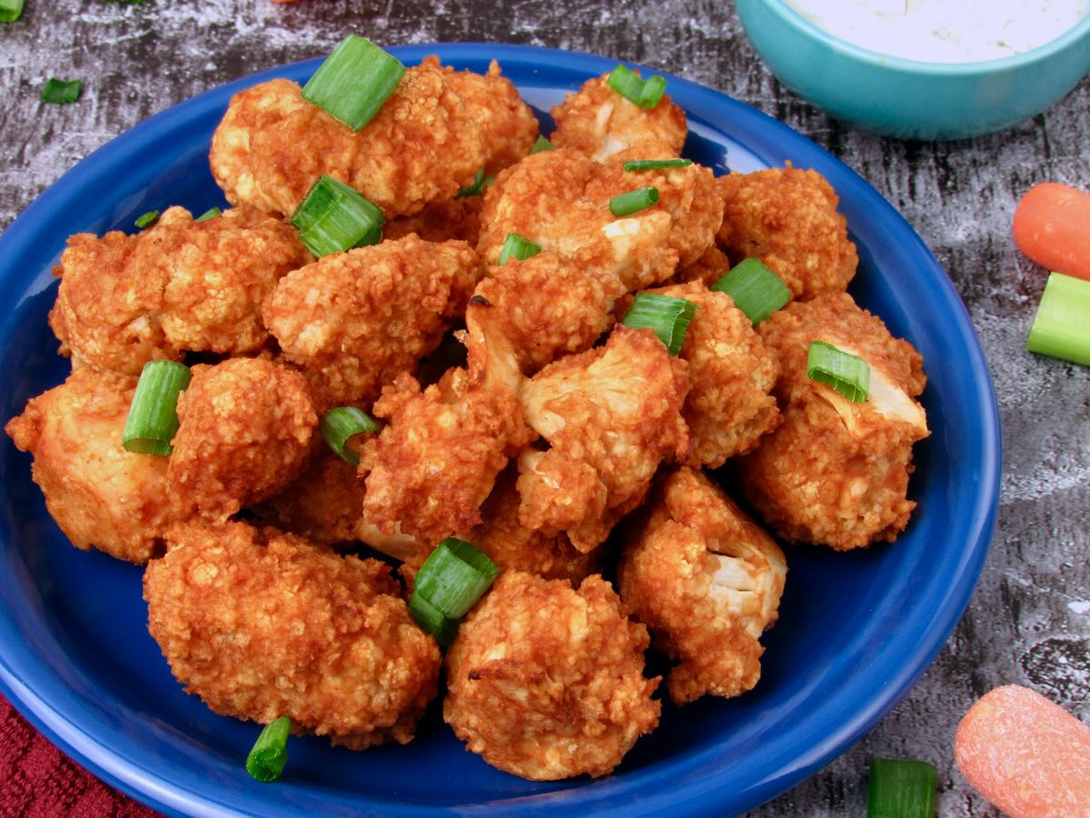 Buffalo Cauliflower served as a party snack with green onion and vegan ranch dip.