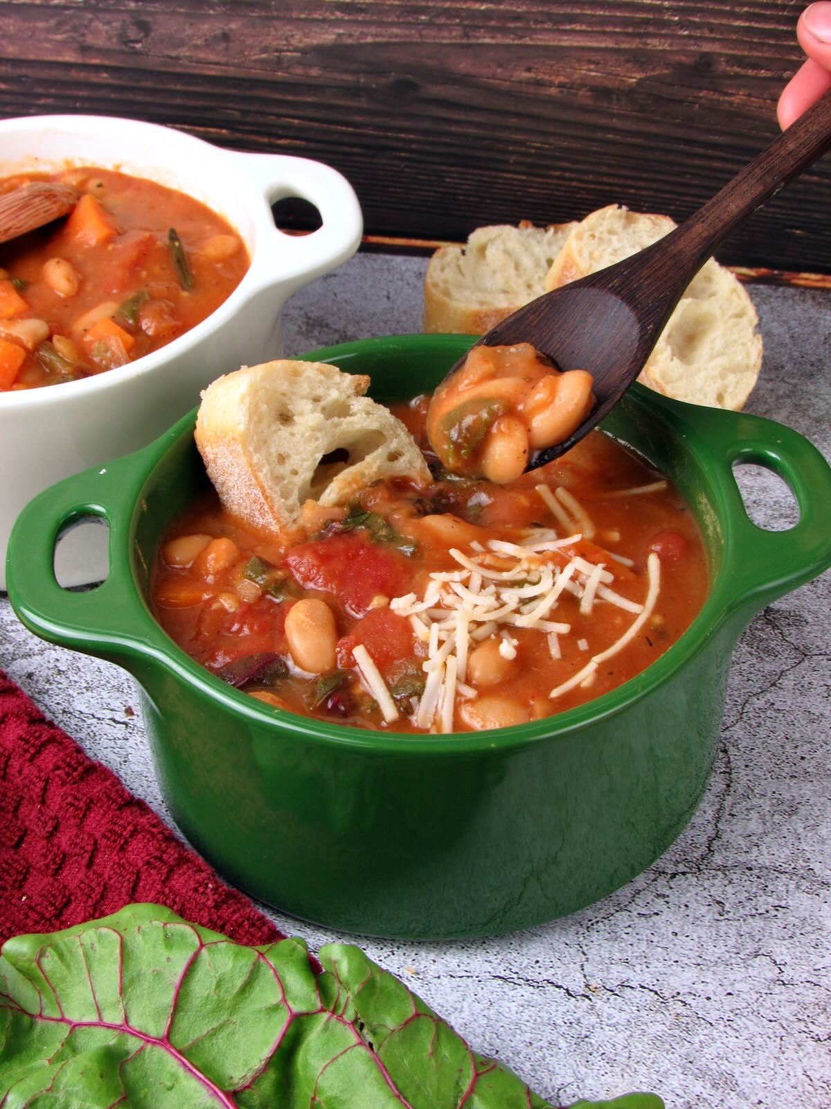 Spoonful of White Bean Soup, topped with vegan parmesan and crusty bread.