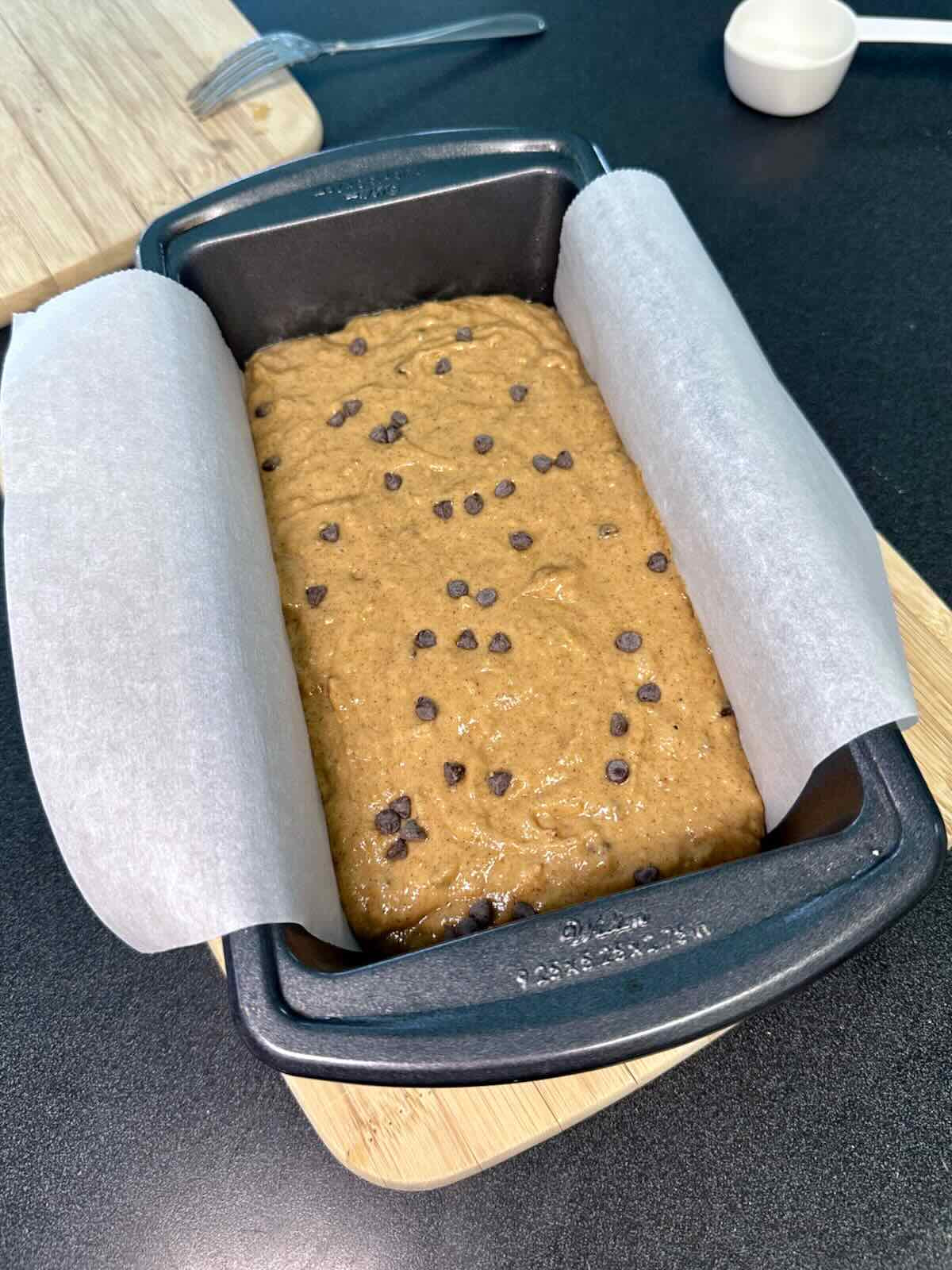 Banana bread batter in a prepared baking tray.