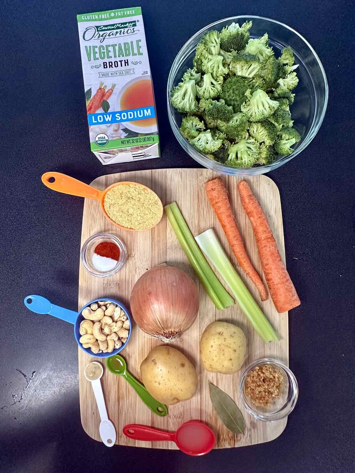 Ingredients for Dairy-Free Broccoli Cheddar Soup, including potato, cashews, carrots, broccoli, and nutritional yeast.