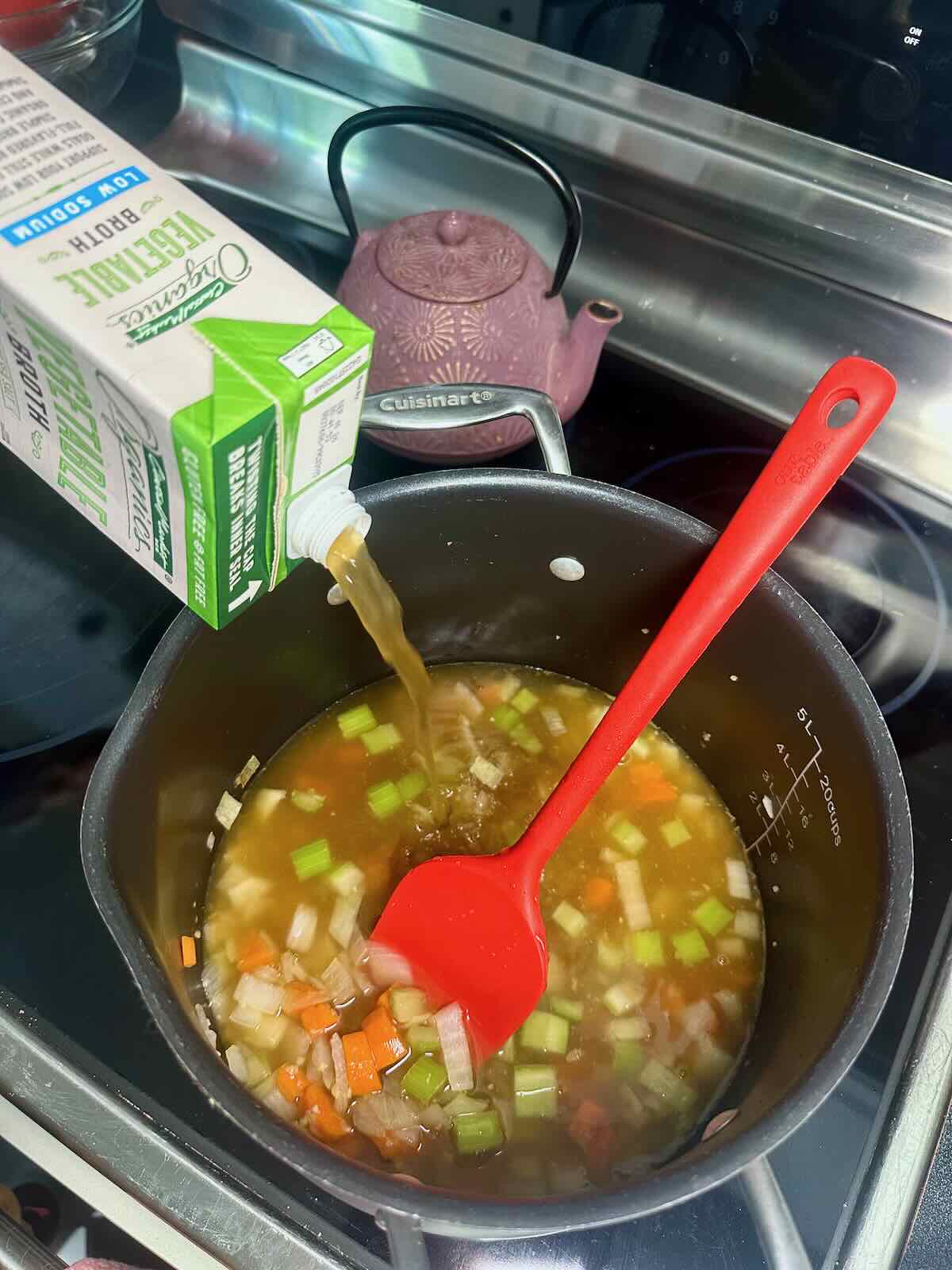 Boiling veggie broth for a dairy-free soup base.