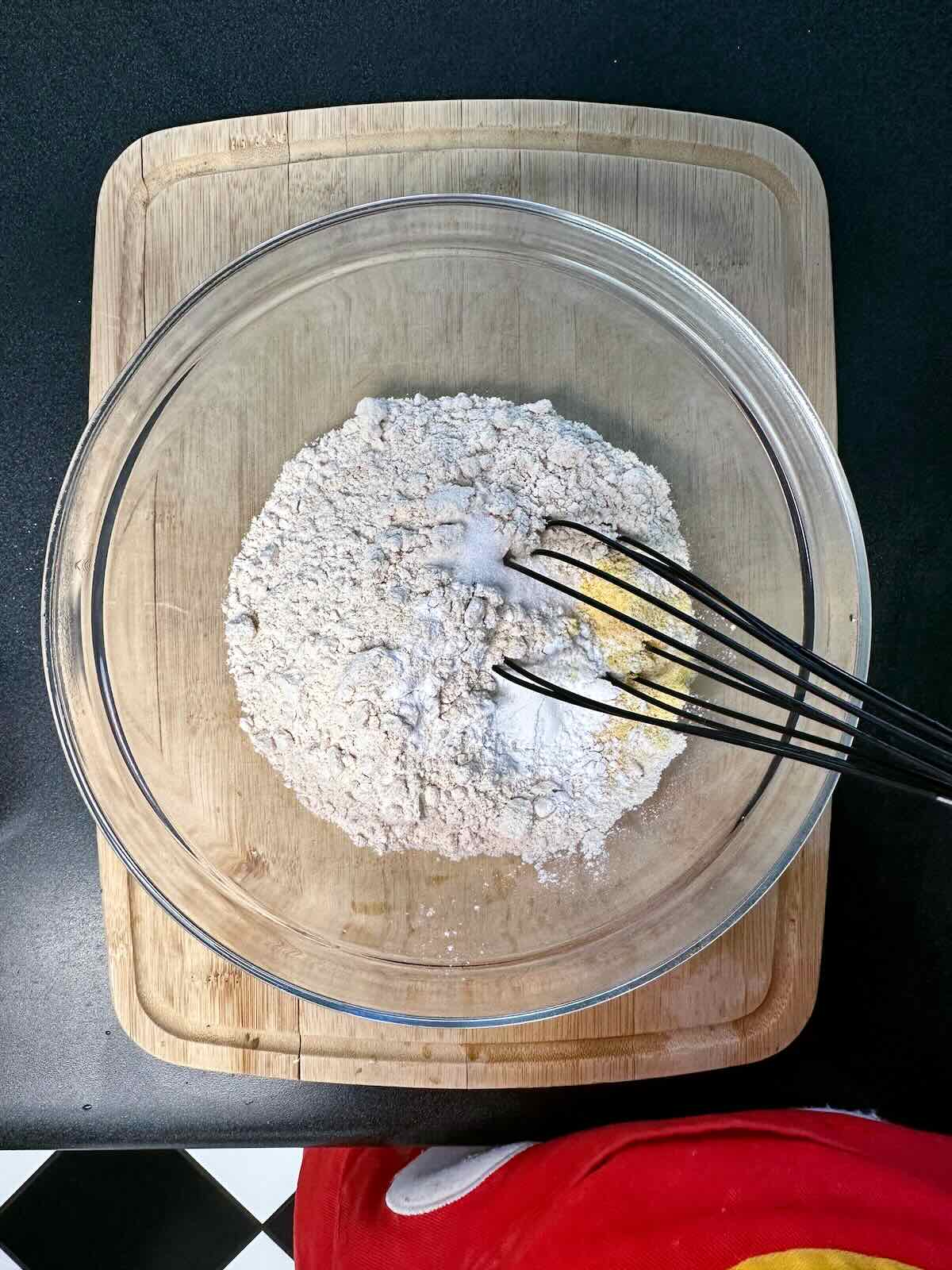 Whisking dry ingredients in a mixing bowl.