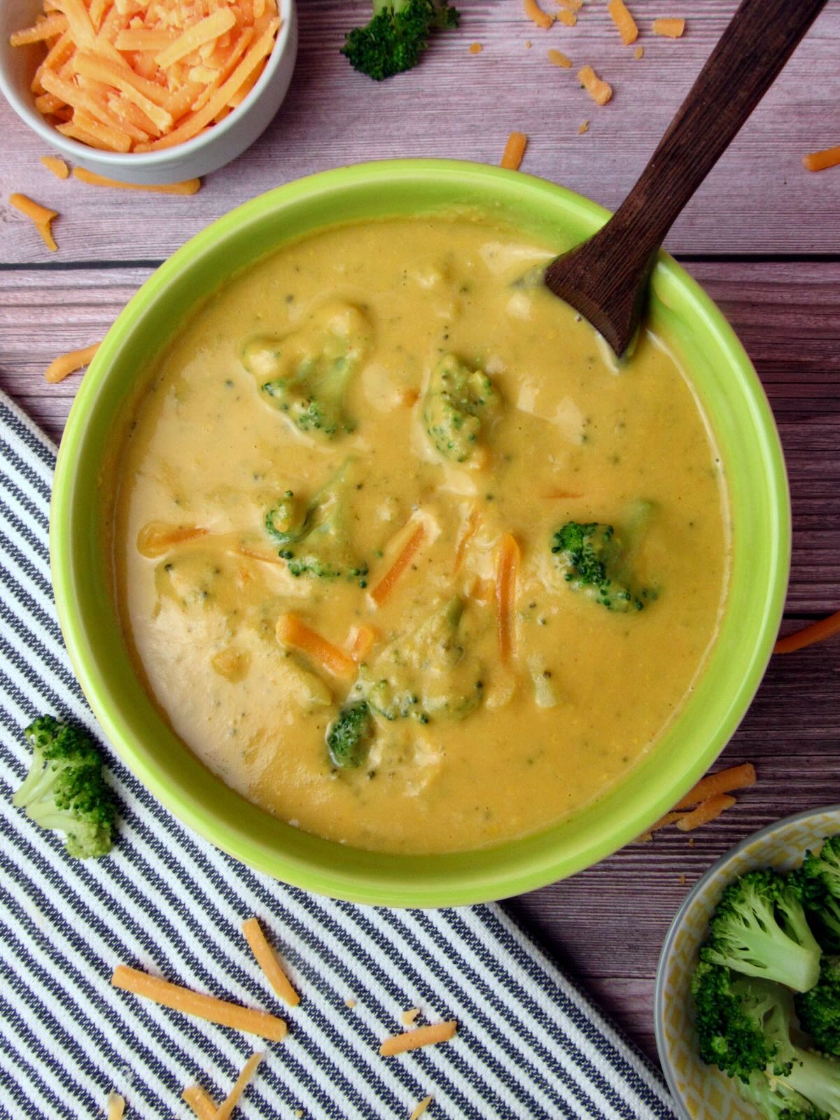Meal prep friendly vegan cheddar broccoli soup, served with steamed broccoli.
