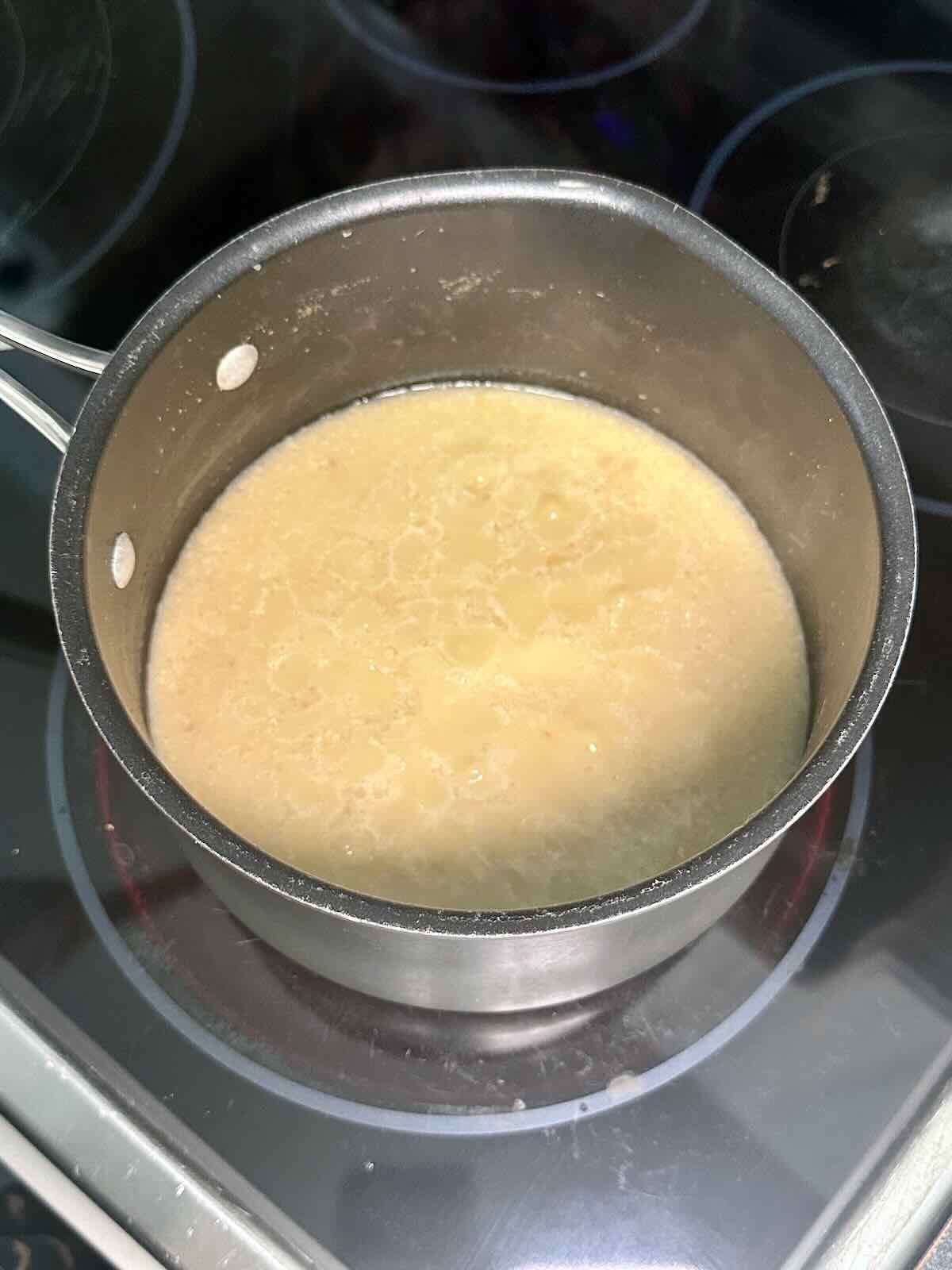 Coconut milk, water, and rice coming to a simmer for creamy coconut rice buddha bowls.