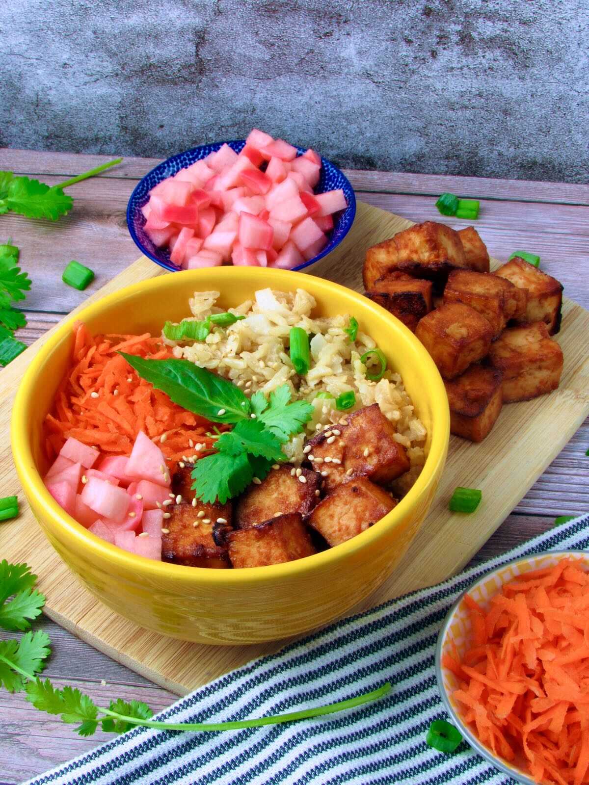 Sriracha Tofu Buddha Bowl with pickled veggies, fresh herbs, and carrots.