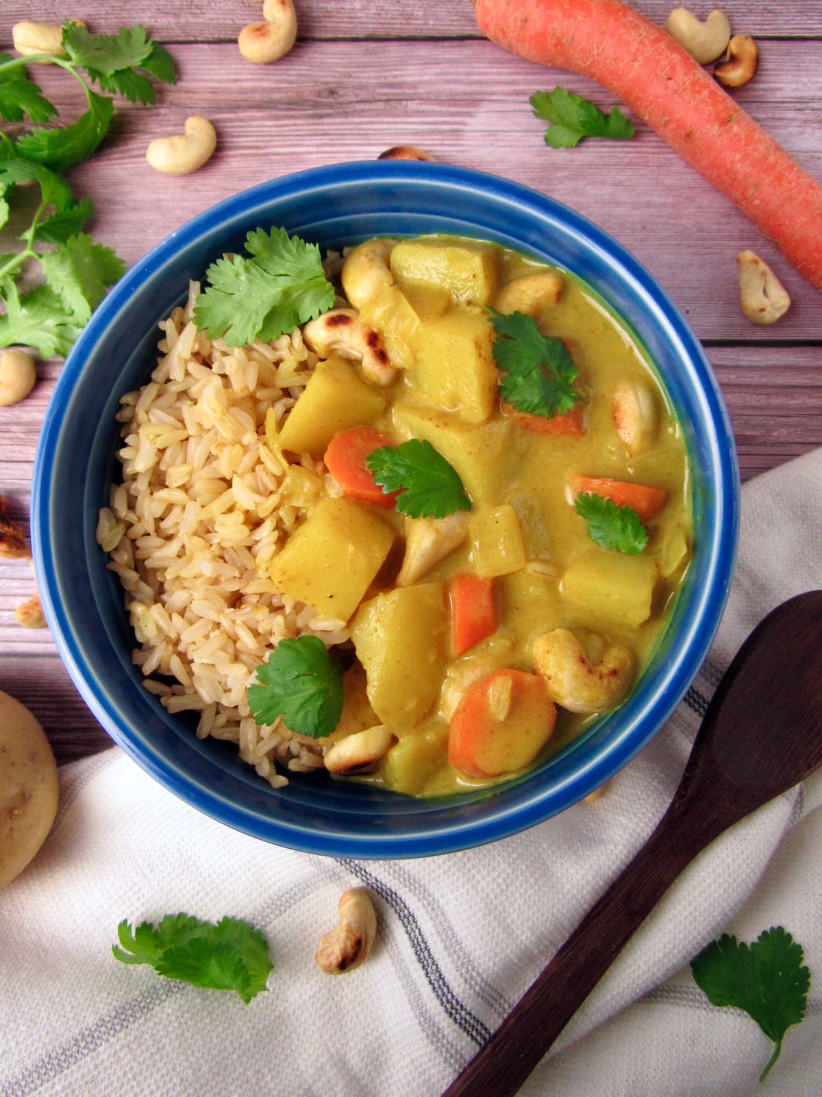 Creamy Coconut Curry with potatoes and carrots, served with brown rice and cilantro.