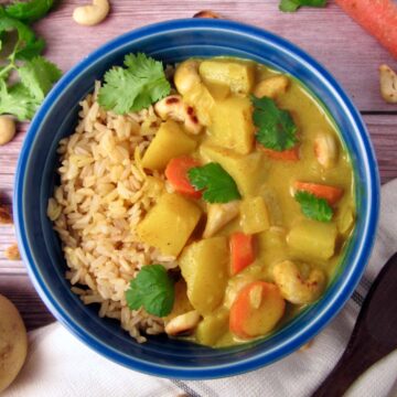 Overhead view of Vegan Creamy Coconut Potato Curry served with brown rice and cilantro.