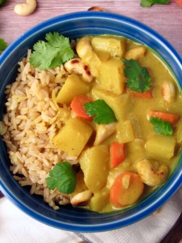 Overhead view of Vegan Creamy Coconut Potato Curry served with brown rice and cilantro.
