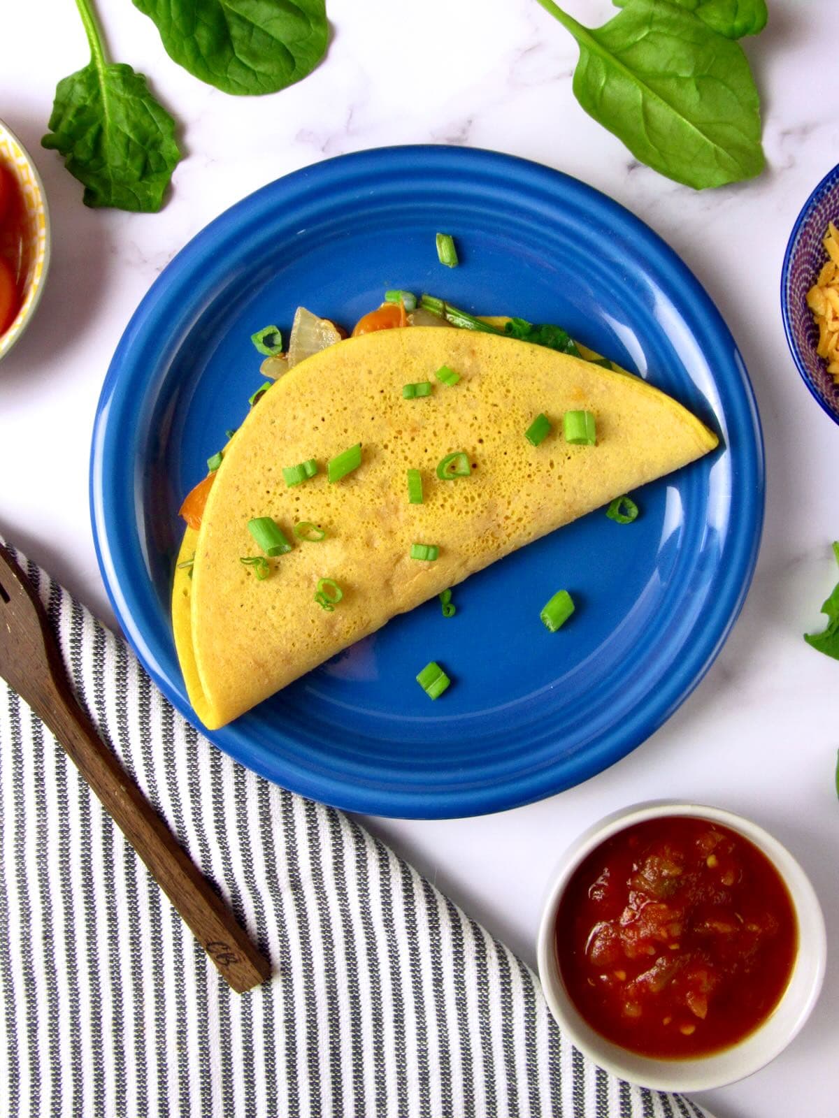 Vegan omelet, served with salsa and fresh chives.