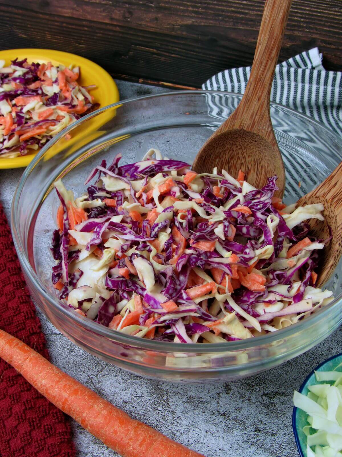 Fresh vegan coleslaw in a bowl, made with crunchy shredded green and red cabbage, carrots, and a creamy tangy dressing.