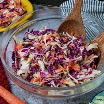 Bowl of creamy vegan coleslaw made with shredded green and red cabbage and carrots.