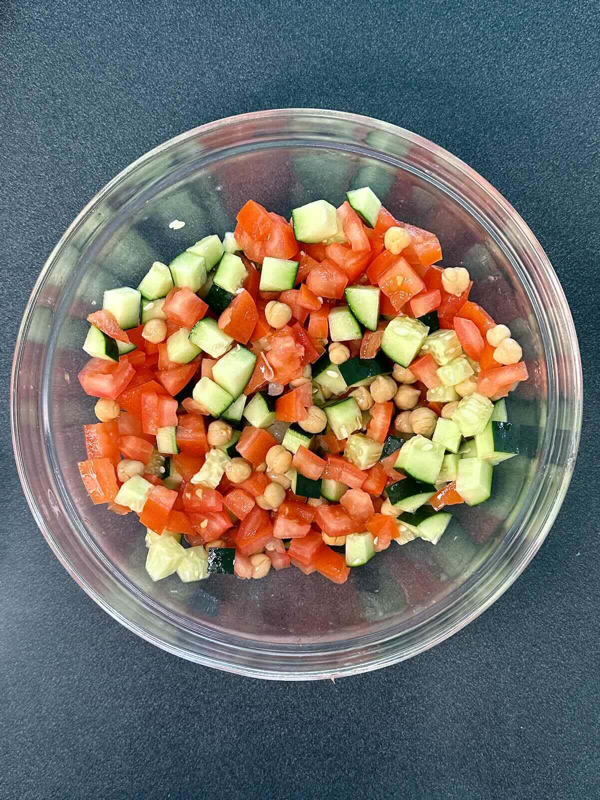 Fresh tomatoes, cucumber, and chickpeas mixed together for a Mediterranean Couscous Salad.