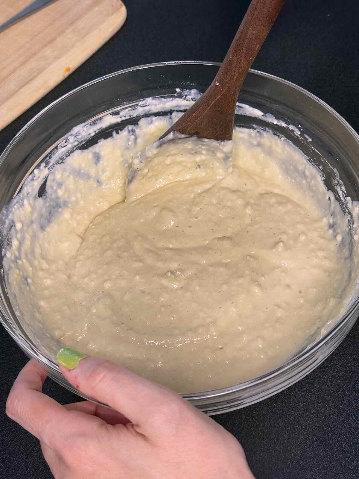 Adding wet ingredients to dry ingredients for eggless pancakes.