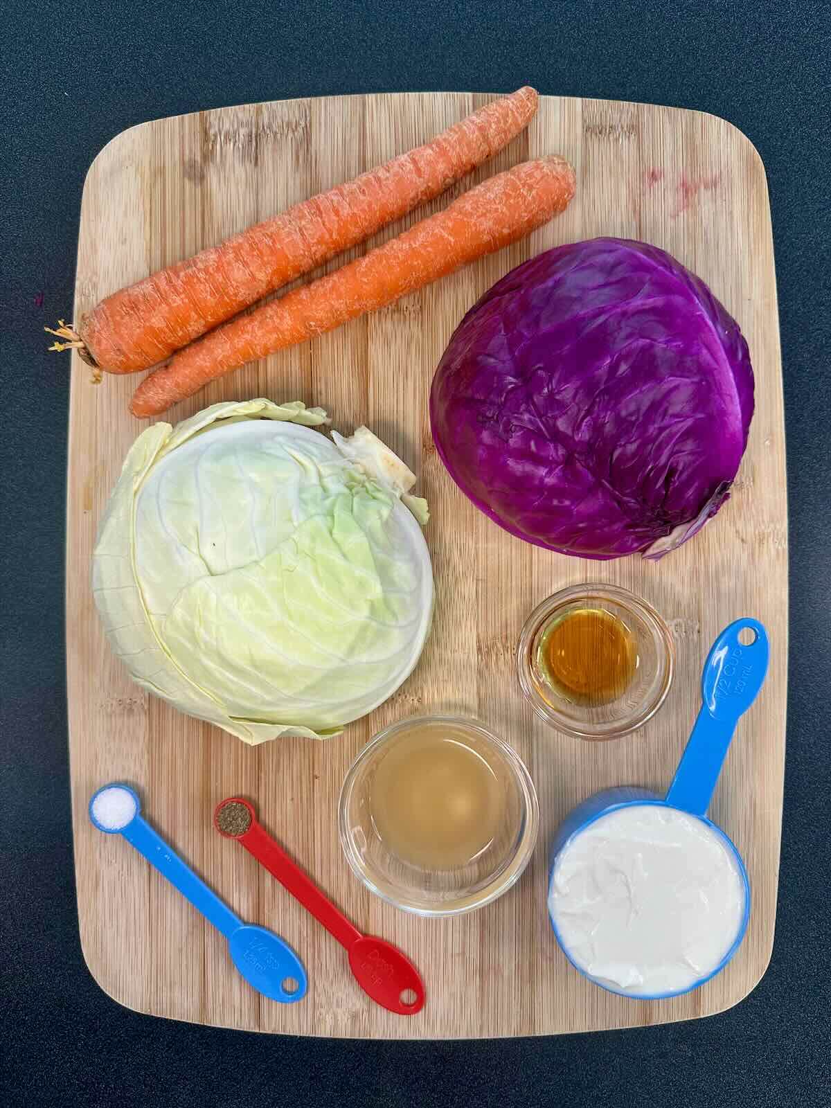 Ingredients for easy vegan coleslaw recipe, including fresh cabbage, carrot, apple cider vinegar, and vegan mayo.