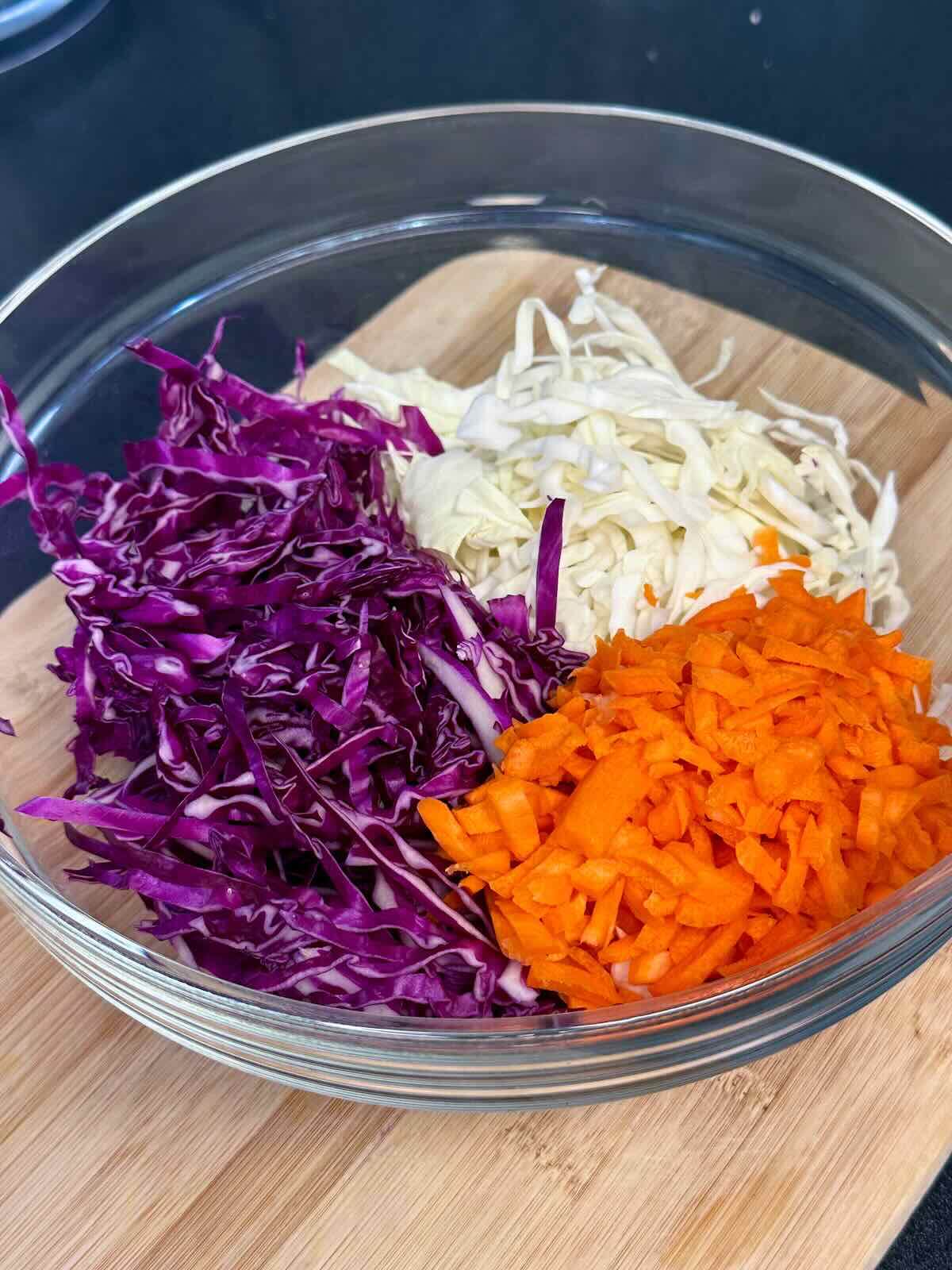 Shredded cabbage and grated carrots combined in a bowl.
