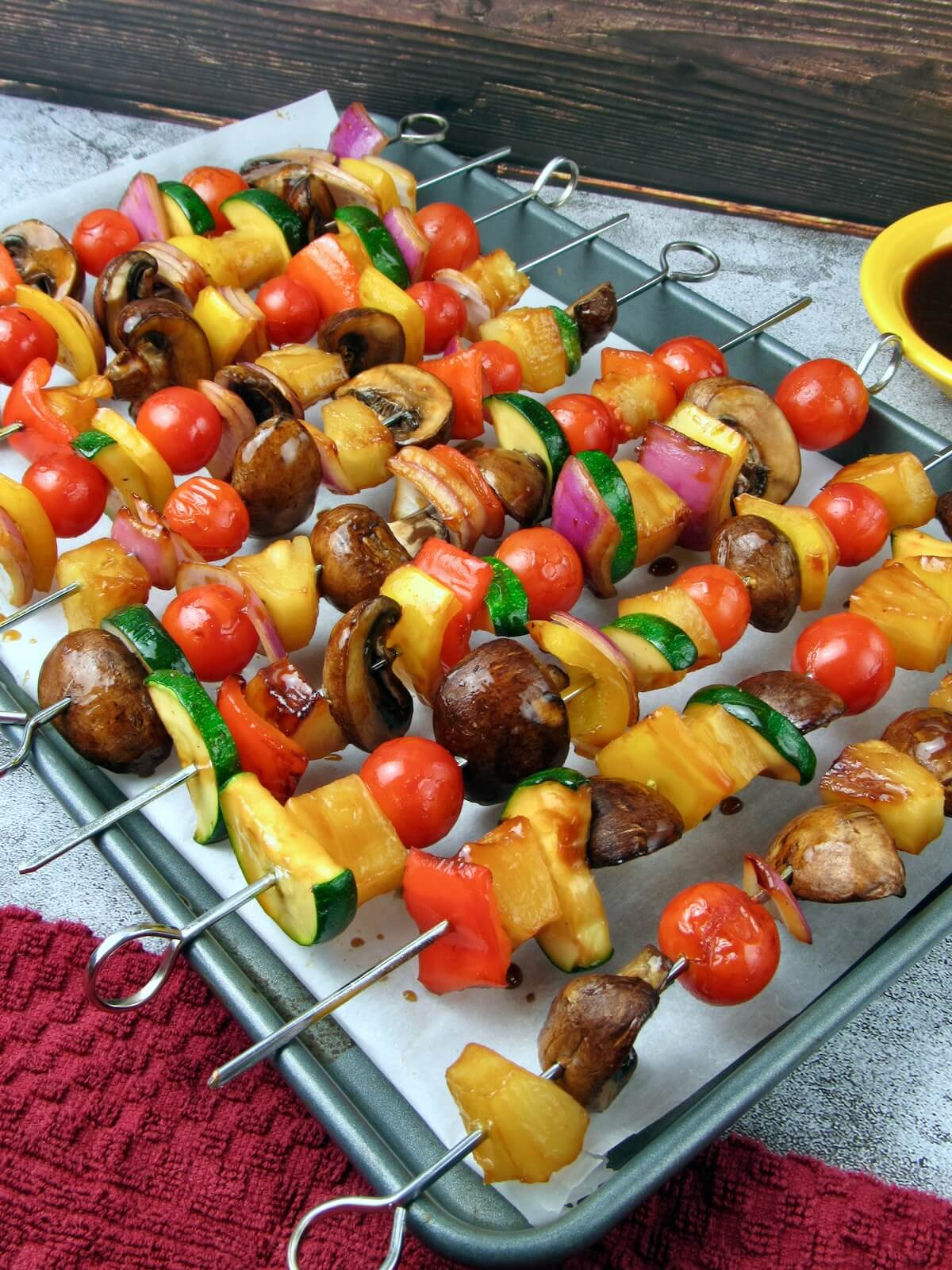Pineapple veggie kebabs on a baking sheet, marinated in vegan teriyaki marinade.