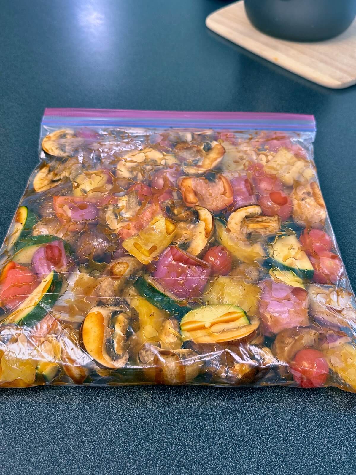 Mushrooms, bell peppers, zucchini, red onion, and cherry tomatoes marinating with teriyaki sauce.