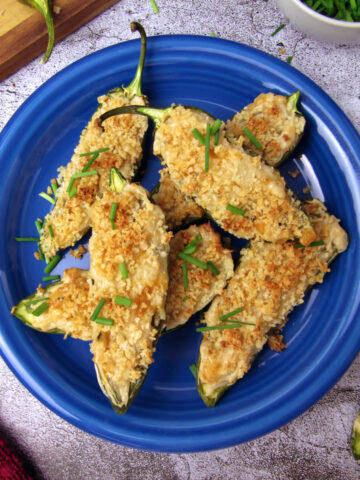 Overhead view of baked vegan jalapeño poppers, served on a blue plate.