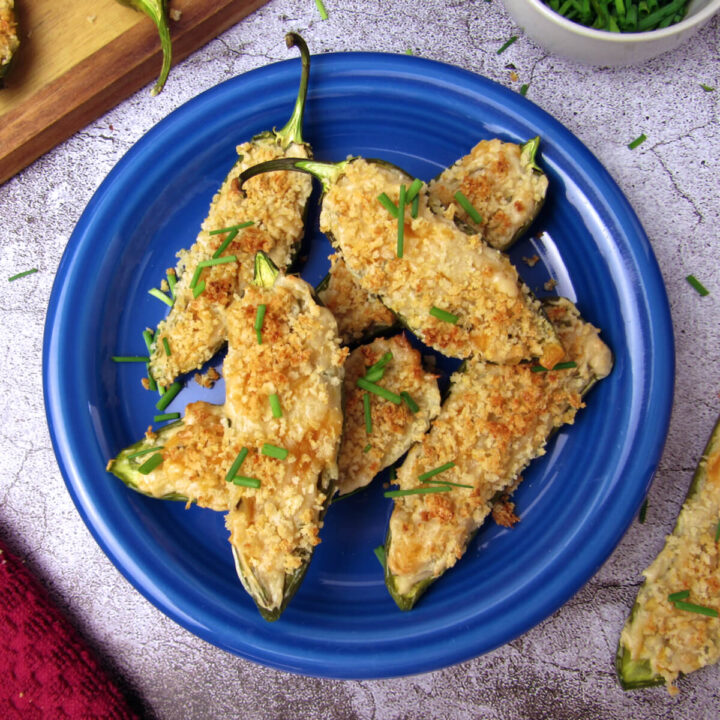 Overhead view of baked vegan jalapeño poppers, served on a blue plate.