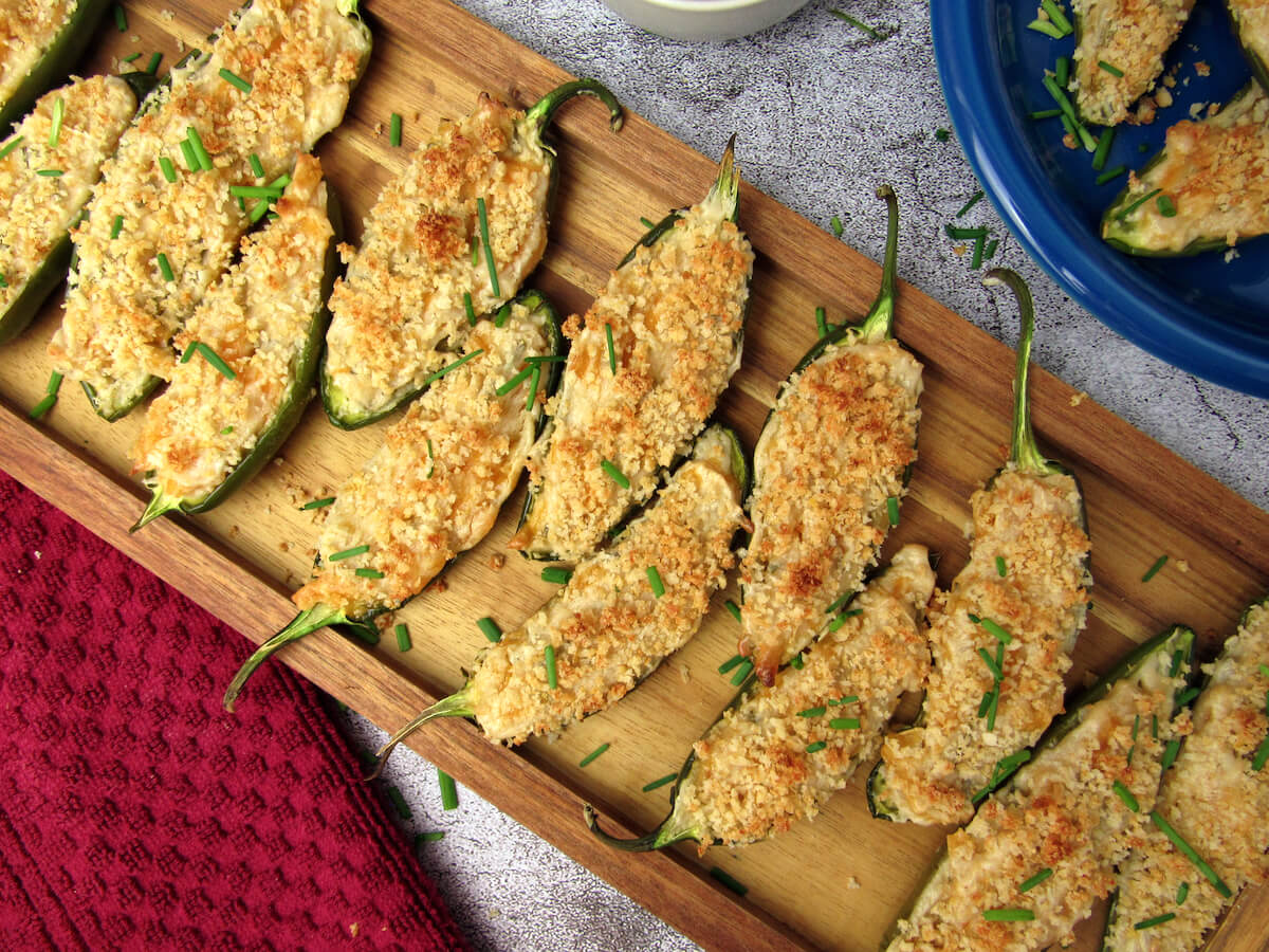 Vegan jalapeño poppers with a creamy filling, fresh chives, and golden crispy breadcrumb topping.