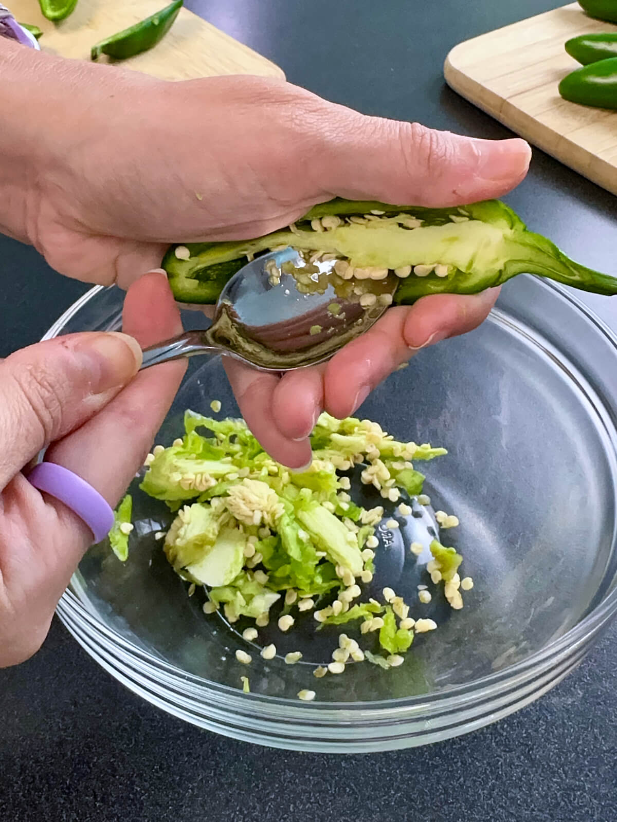Scooping out the seeds and membranes of a jalapeño.