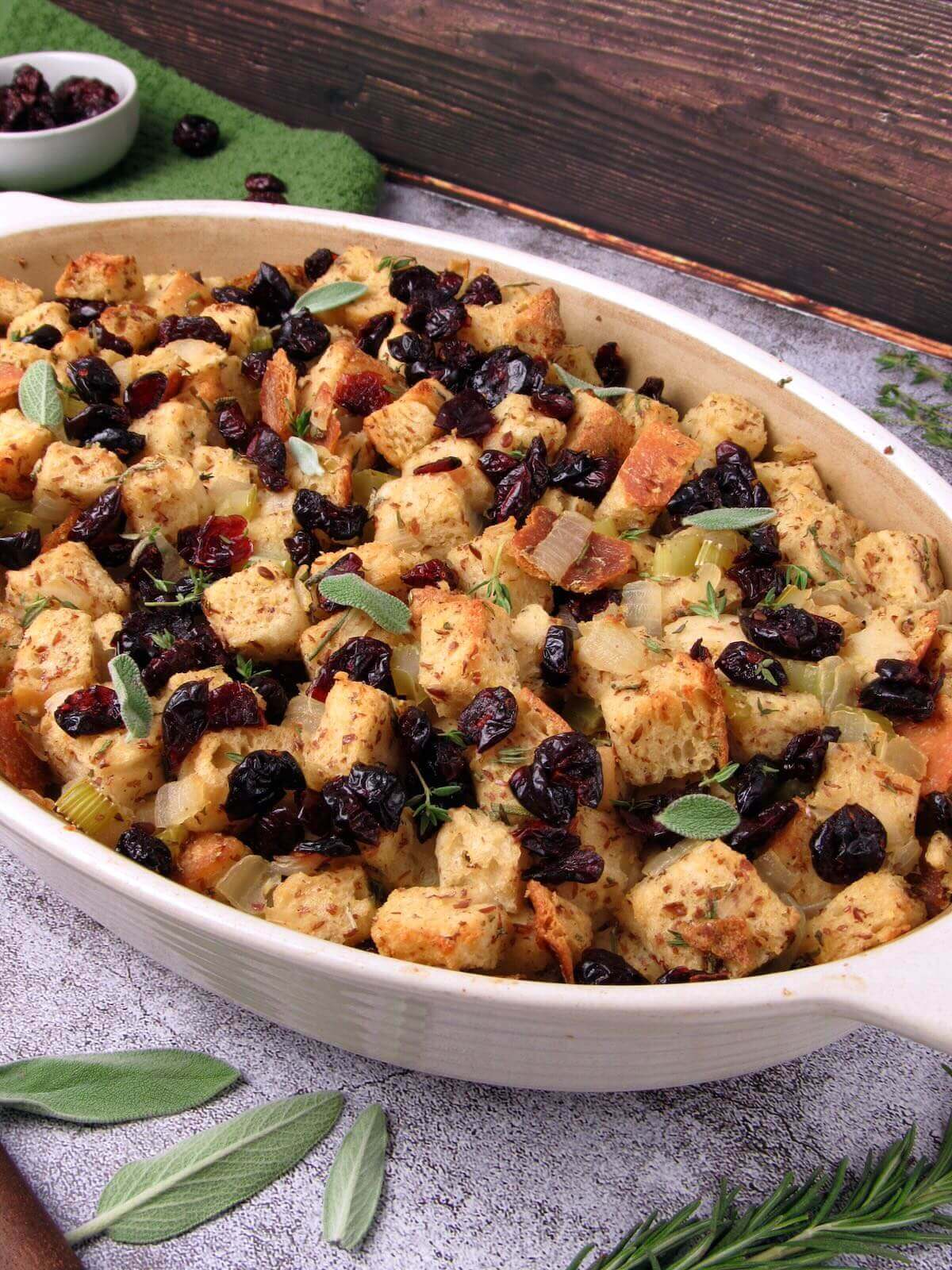 Vegan sourdough stuffing with fresh herbs and dried cranberries in a baking dish.